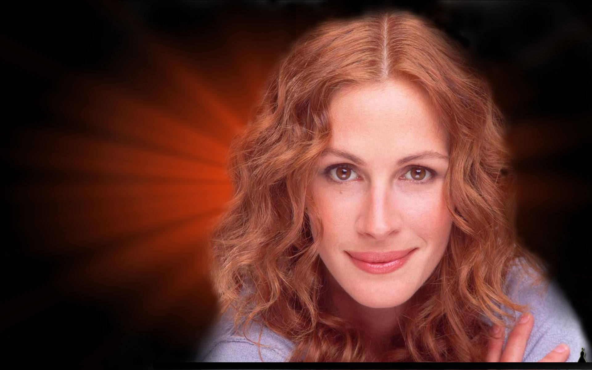 Julia Roberts 桌布 壁紙 — 一位擁有波浪紅髮的女性在黑暗背景中，伴隨著耀眼的橙色光束，溫柔地微笑。