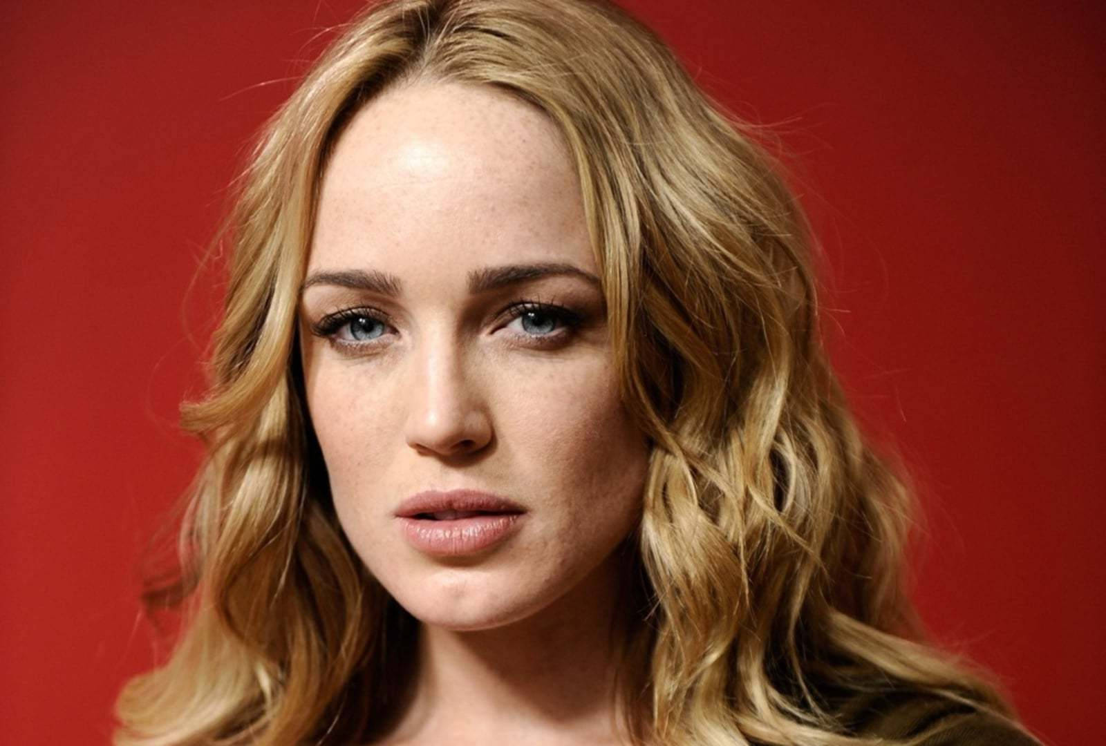 金髮藍眼的女性在紅色背景下看著相機。 — Caity Lotz 動圖 壁紙
