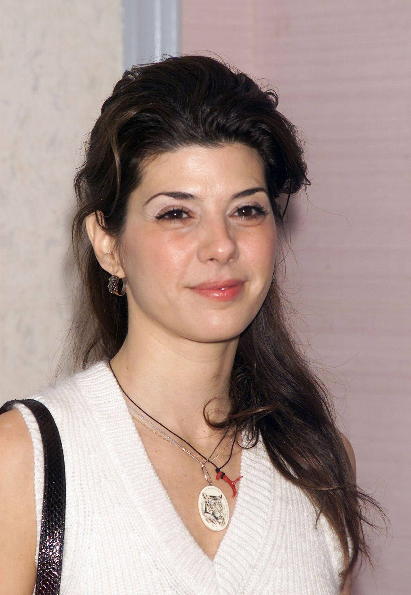 Celebrity 桌布 壁紙 — 一位擁有深色波浪長髮的女性，穿著白色針織上衣和層疊項鍊，溫柔地微笑。