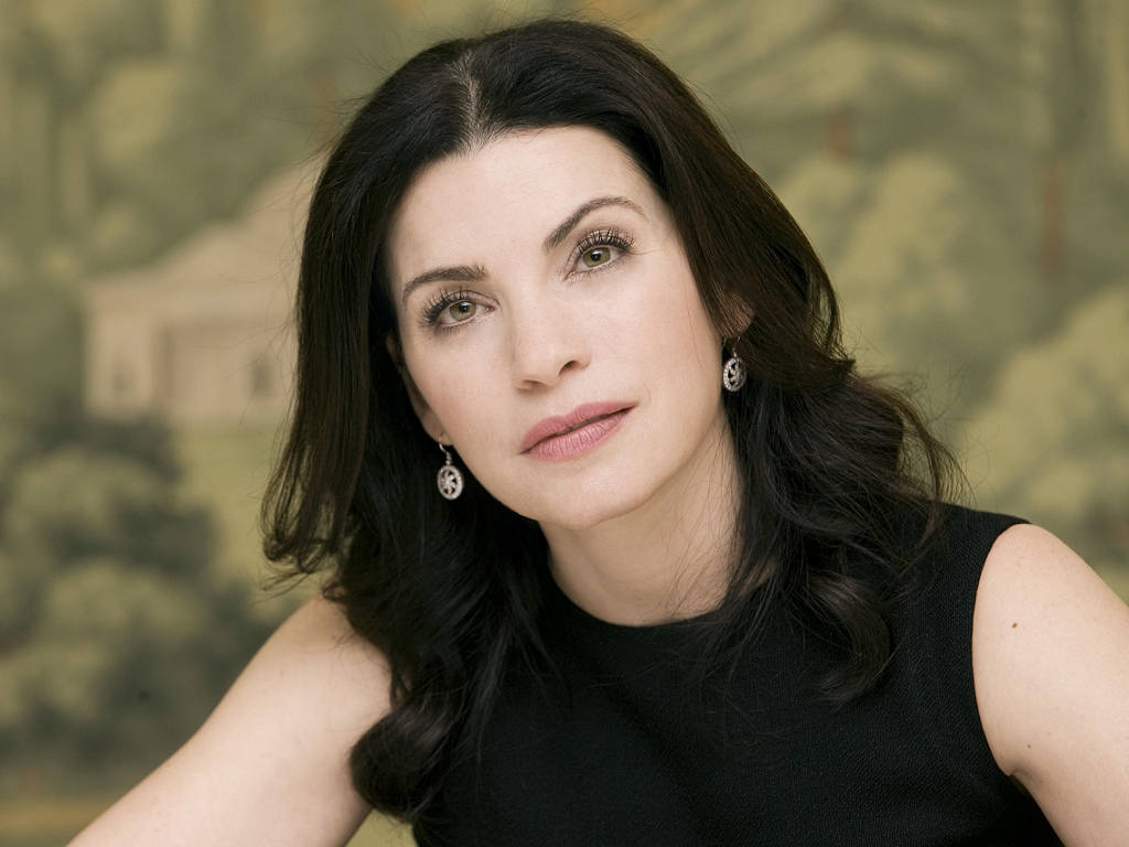 Celebrity 桌布 壁紙 — 一位擁有深色波浪頭髮和優雅耳環的女性，在模糊的田園風格壁紙背景下溫柔地凝視。