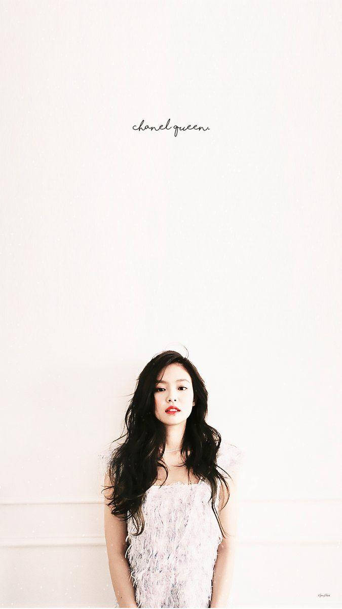 Jennie 桌布 壁紙 — 一位擁有深色波浪頭髮和紅唇的女性，穿著質感白色連衣裙，站在極簡白色牆壁前。