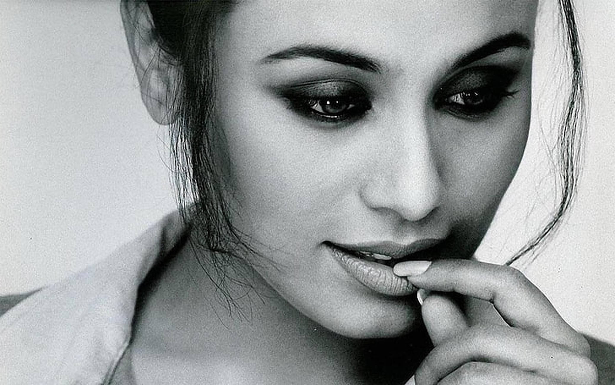 Rani Mukerji 桌布 壁紙 — 一位擁有煙燻眼妝的女性，手指輕觸嘴唇的黑白特寫肖像。