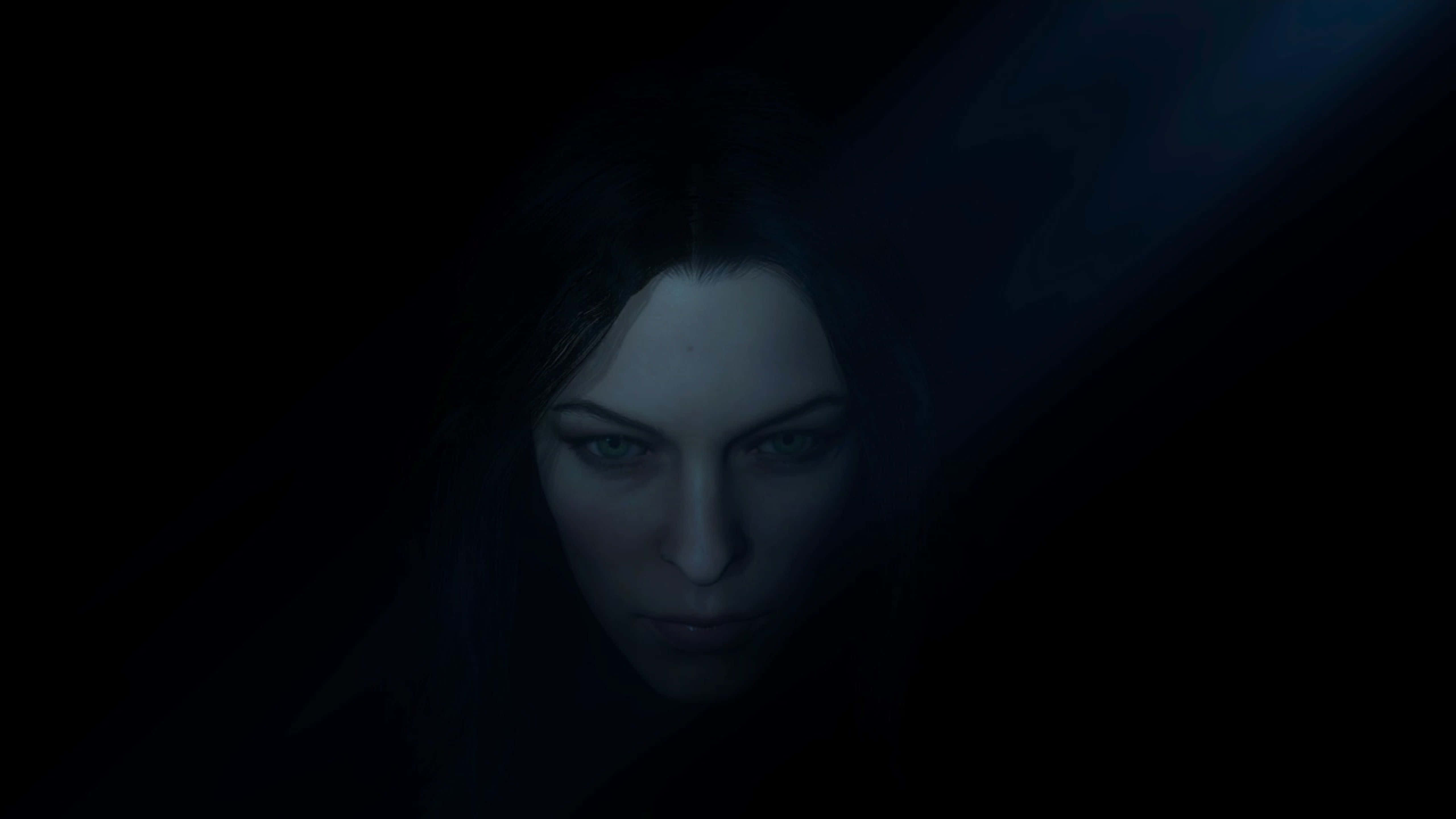 shadow of war 4K 桌布 壁紙 — 一位擁有發光綠色眼睛的女性從被冷藍光照亮的黑暗中凝視著。