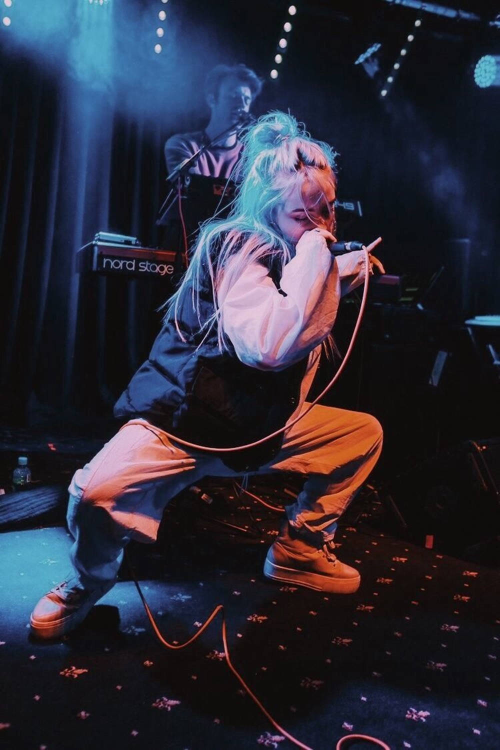 藍髮歌手在燈光舞台上的表演。