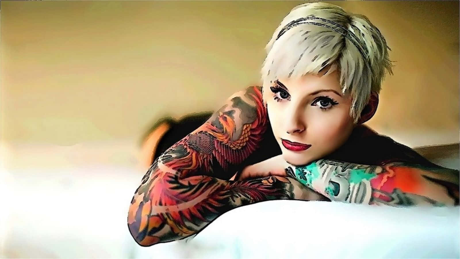 Tattoo 桌布 壁紙 — 一位擁有短白金髮和鮮豔紋身的女性，將手臂擱在白色表面上，直視觀看者。