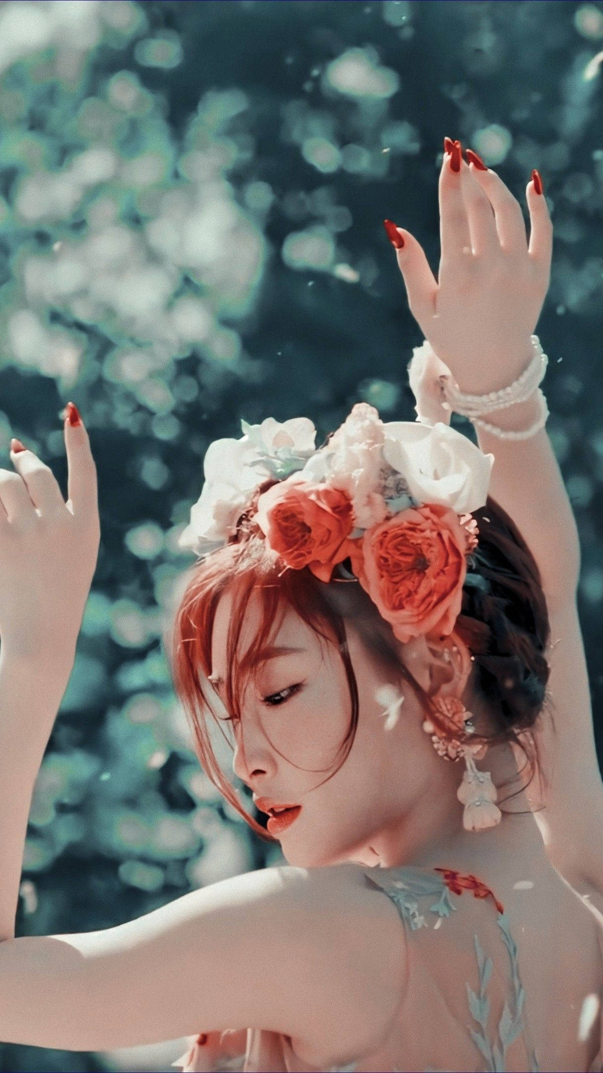Chungha 桌布 壁紙 — 一位擁有紅色指甲和花冠的女性，在柔和的藍色散景背景前舉起雙手。