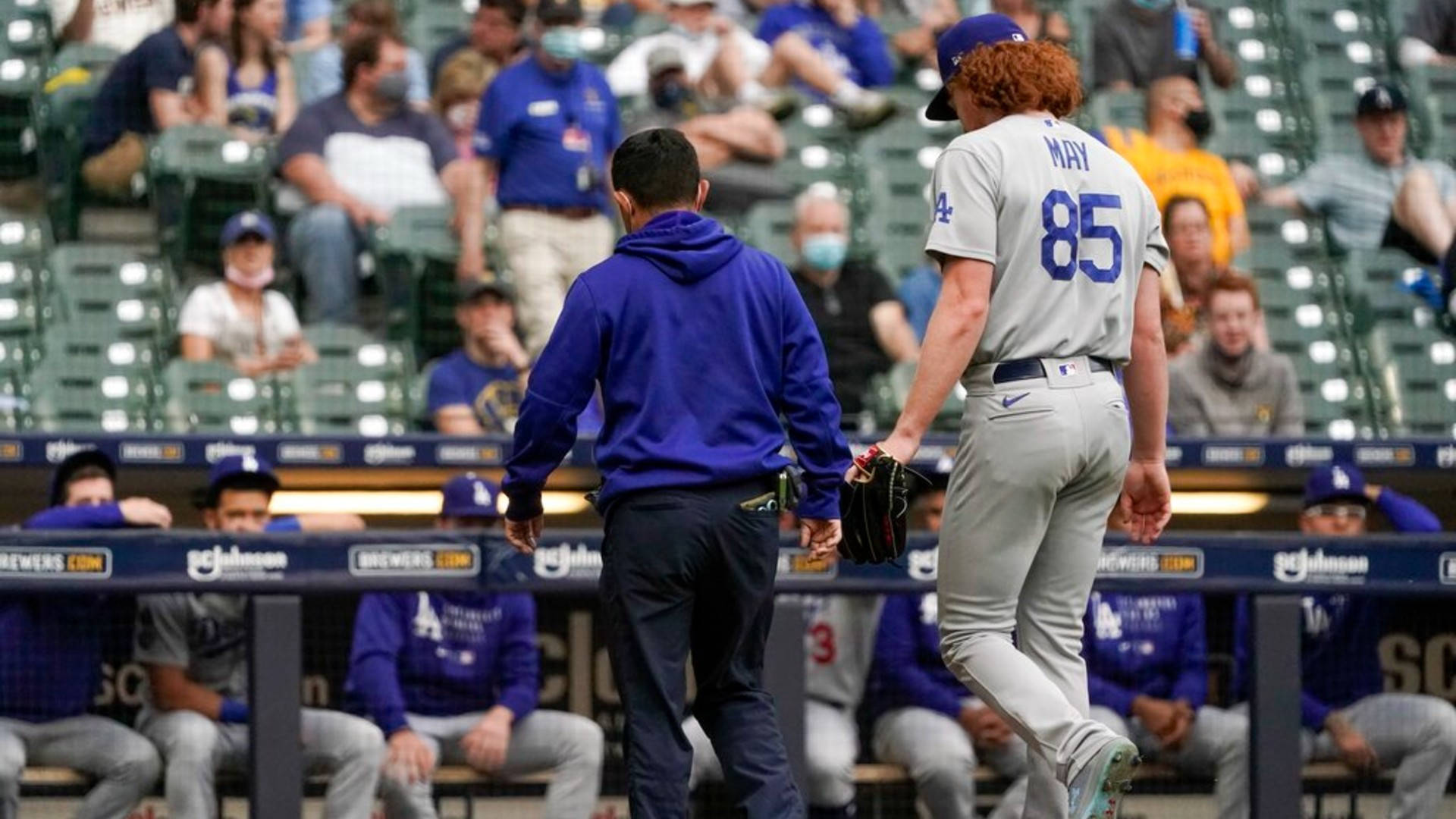 Brewers 桌布 壁紙 — 一位擁有紅色捲髮的棒球運動員離開球員休息區，而教練則穿過體育場座位跟隨他。