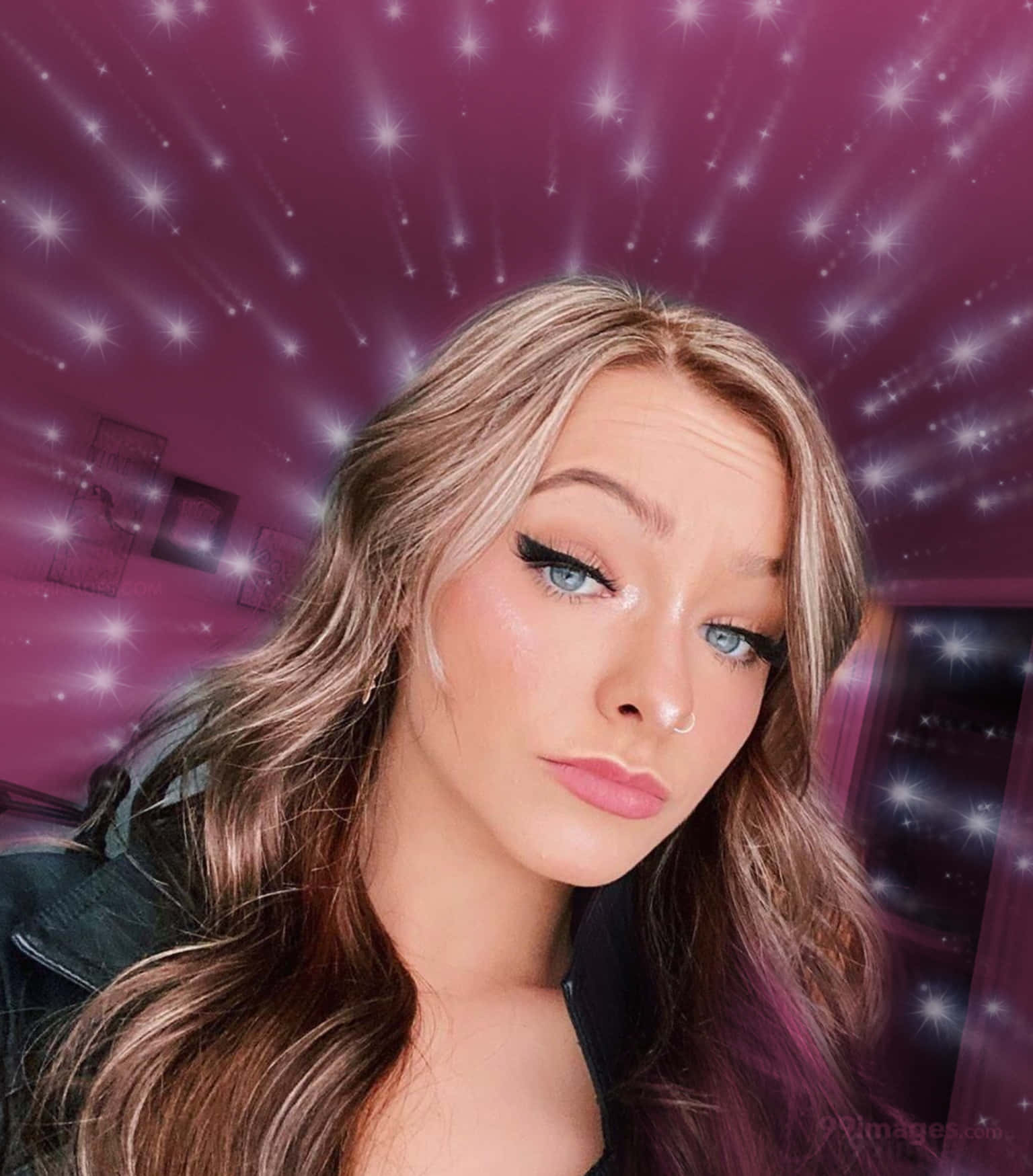 Zoe Laverne 桌布 壁紙 — 一位擁有藍色眼睛和金色頭髮的年輕女性，在充滿活力的紫色星空背景前擺姿勢，伴隨著閃爍的光芒。