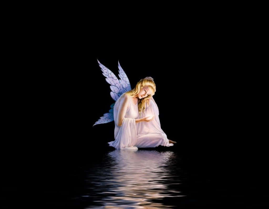 Cute Fairy 桌布 壁紙 — 一位擁有藍色翅膀的寧靜天使跪在黑暗的水中，手持發光球體，面對黑色虛空。