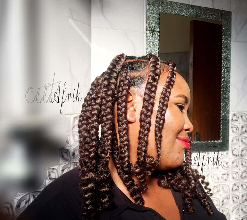 Hairstyle 桌布 壁紙 — 一位擁有複雜深棕色辮子的女士在帶有圖案瓷磚和閃亮鏡子的浴室中溫柔微笑。