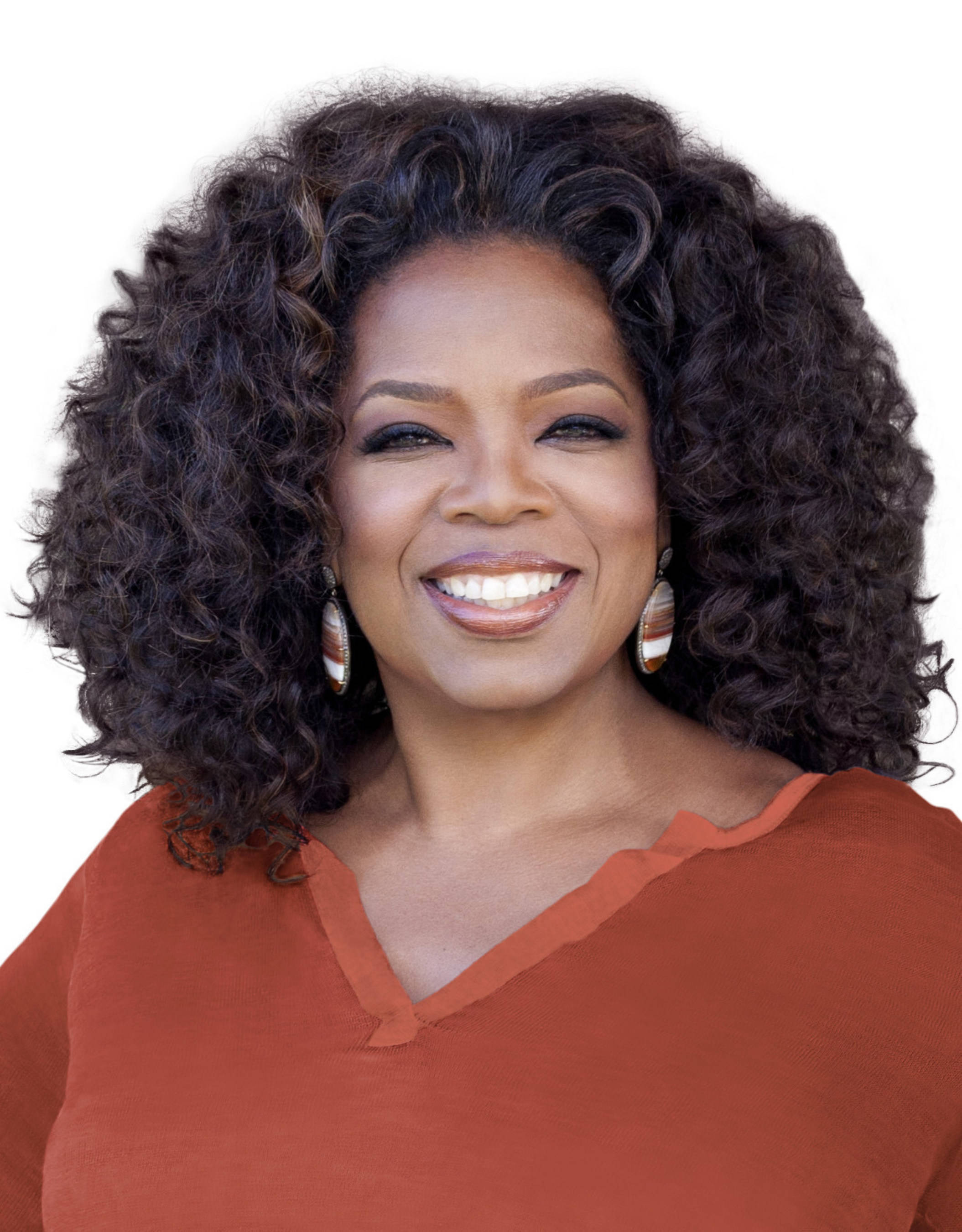 Oprah 桌布 壁紙 — 一位擁有豐盈深色捲髮的容光煥發的女性，在潔白的背景前穿著鏽紅色上衣，溫暖地微笑。