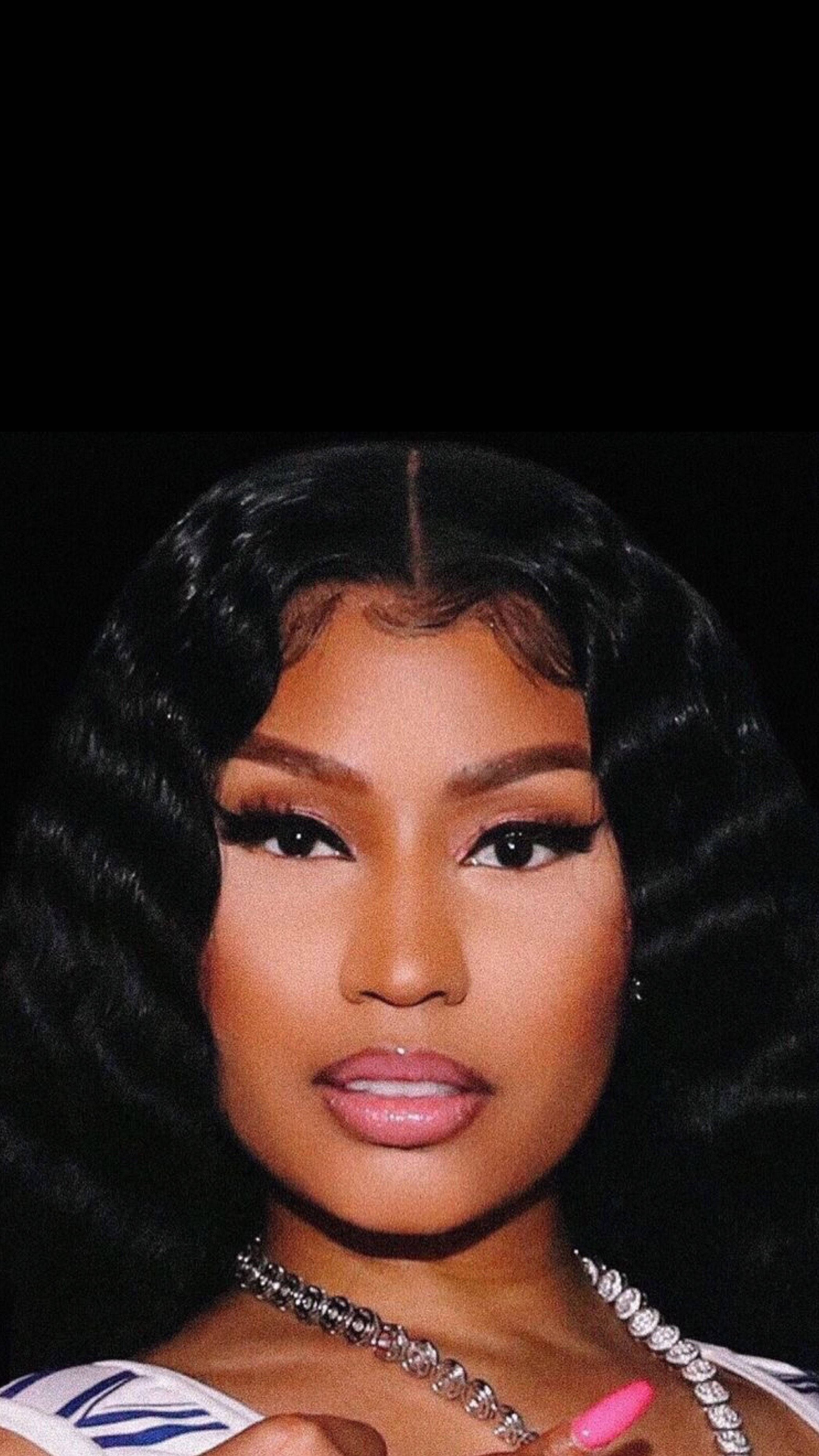 Nicki 桌布 壁紙 — 一位擁有豐盈黑色捲髮和大膽妝容的女性，在純黑背景下的迷人肖像。