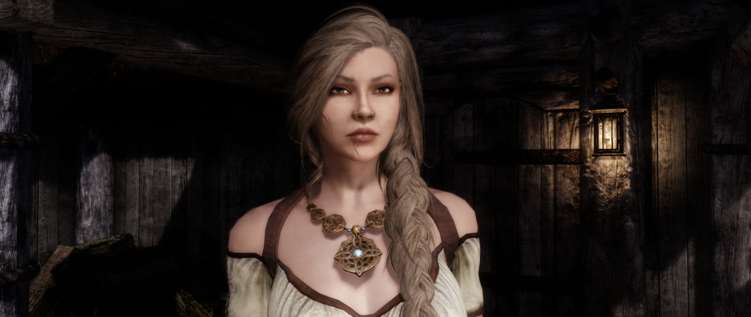 Skyrim Delphine 桌布 壁紙 — 一位擁有辮子金髮和華麗項鍊的女性站在一間由單一燈籠照亮的昏暗木屋中。