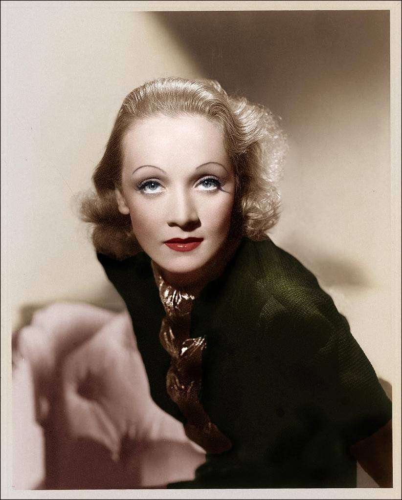 Marlene Dietrich 桌布 壁紙 — 一位擁有金色波浪髮型和鮮豔紅唇的迷人女性，在復古工作室肖像中直視鏡頭。