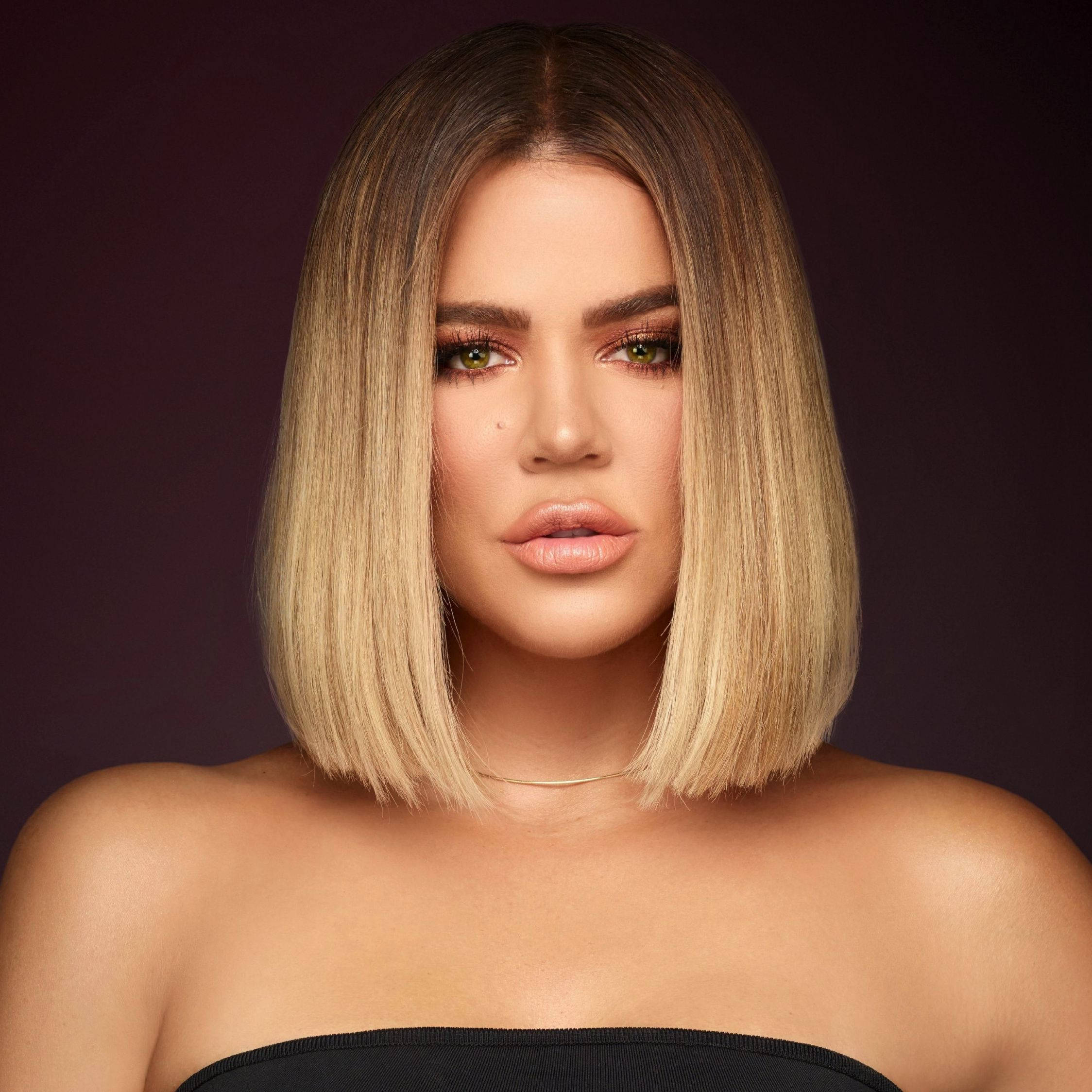 khloe 桌布 壁紙 — 一位擁有金色鮑伯頭和綠色眼睛的女性，在深紫色背景下直視鏡頭。