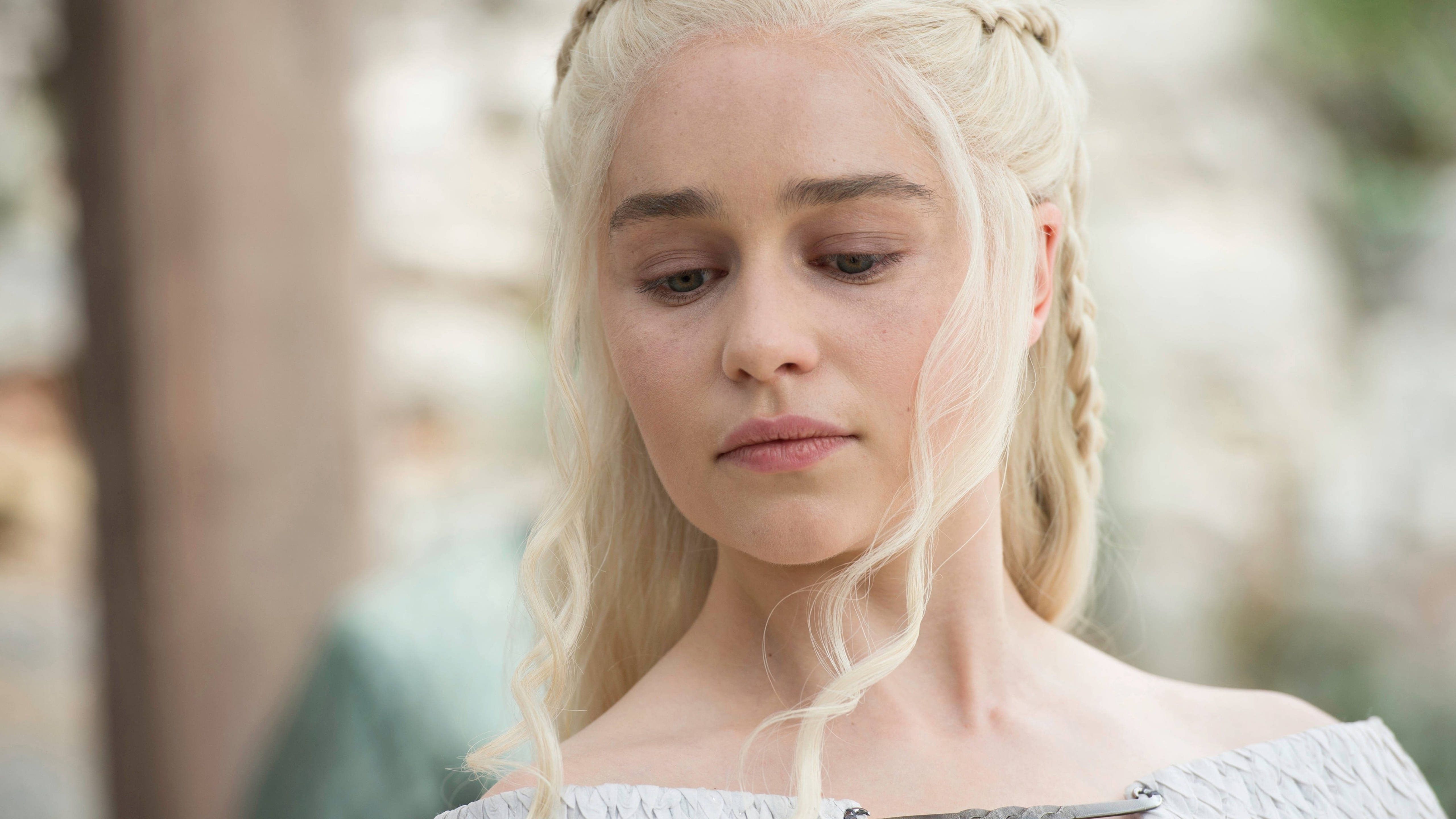 daenerys 桌布 壁紙 — 一位擁有鉑金色辮子頭髮、表情嚴肅的女性穿著露肩禮服的近距離肖像。