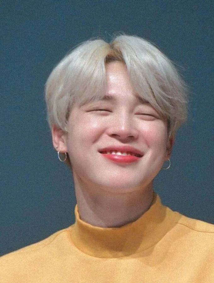 BTS 智旻 桌布 壁紙 — 一位擁有鉑金色頭髮和鮮紅嘴唇的年輕男子，在純青色背景前洋溢著喜悅。