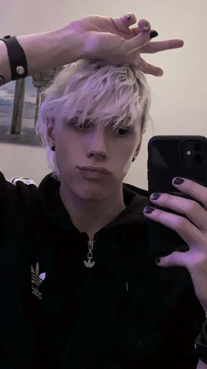 emo 美學 桌布 壁紙 — 一位擁有鉑金色頭髮和黑色指甲油的人，在昏暗的房間裡穿著黑色連帽衫自拍。