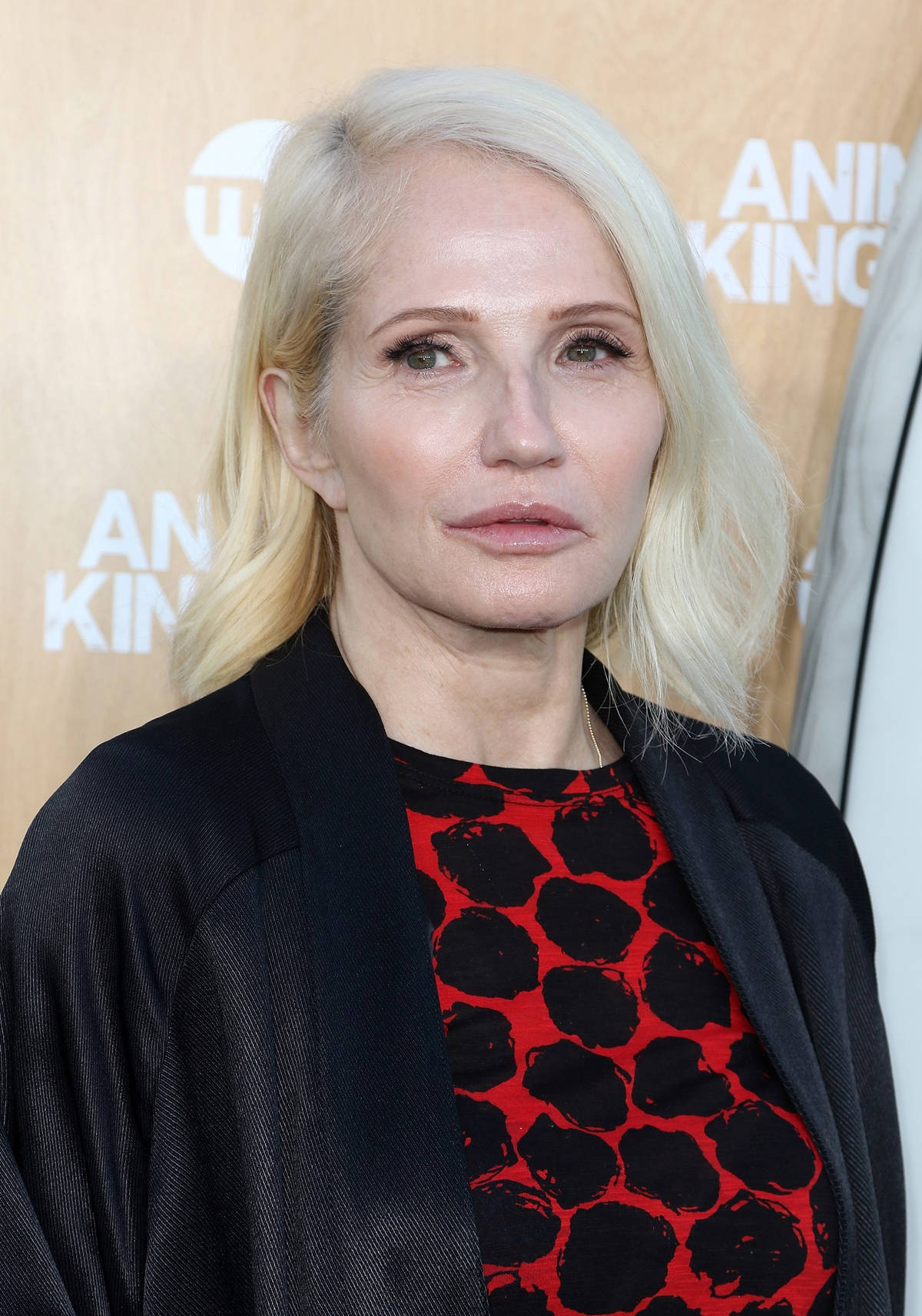 Celebrity 桌布 壁紙 — 一位擁有鉑金色頭髮的女性在活動中穿著黑色外套，內搭紅黑圖案上衣。