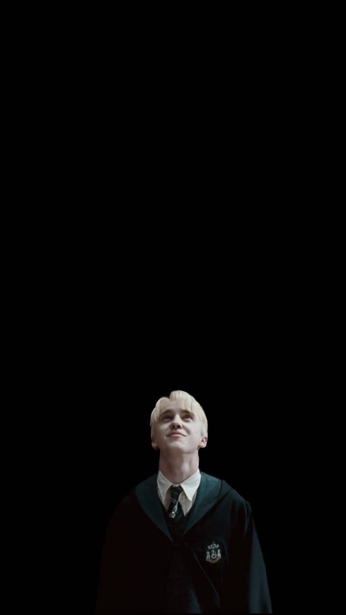draco 桌布 壁紙 — 一位擁有鉑金色頭髮的年輕男子身穿深色長袍，在純黑背景下向上凝視。