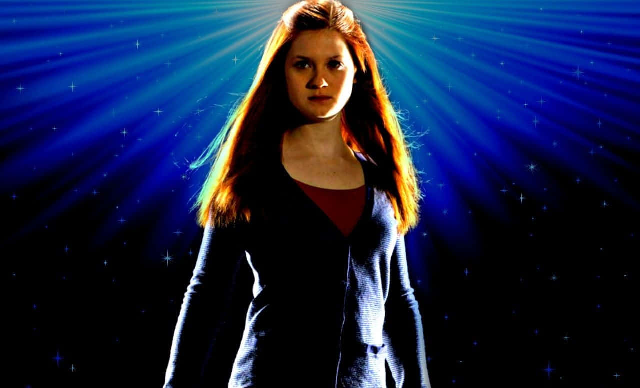 Ginny Weasley 桌布 壁紙 — 一位擁有長紅髮的女性站在帶有星爆和發光光線的宇宙藍色背景前。