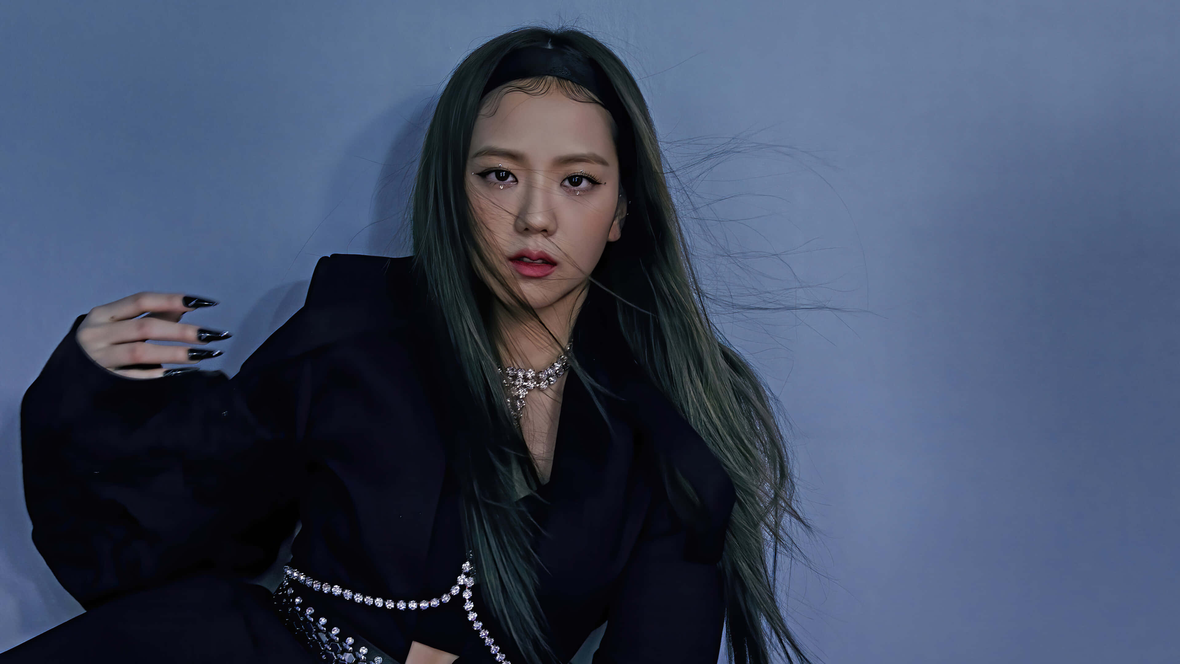 BLACKPINK 桌布 壁紙 — 一位擁有長綠色頭髮和黑色指甲的女性，穿著黑色服裝，在清涼的藍色工作室背景前擺姿勢。