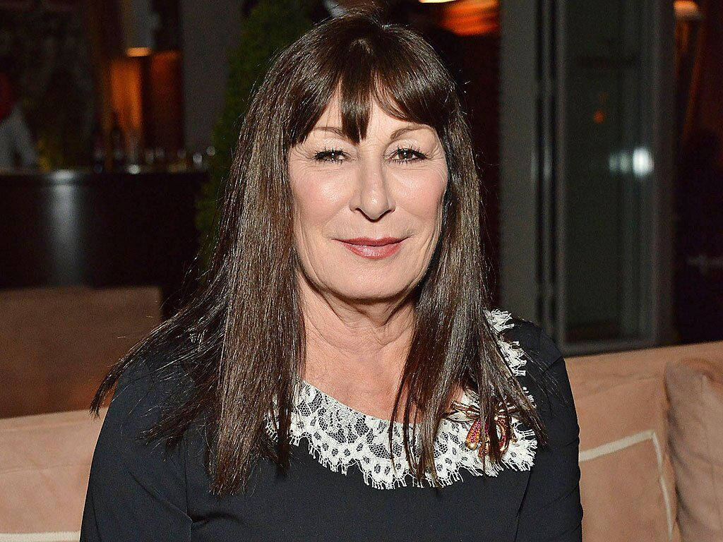 Celebrity 桌布 壁紙 — 一位擁有長長棕色頭髮、穿著黑色蕾絲邊上衣的女性，在溫暖燈光的室內環境中溫柔微笑。
