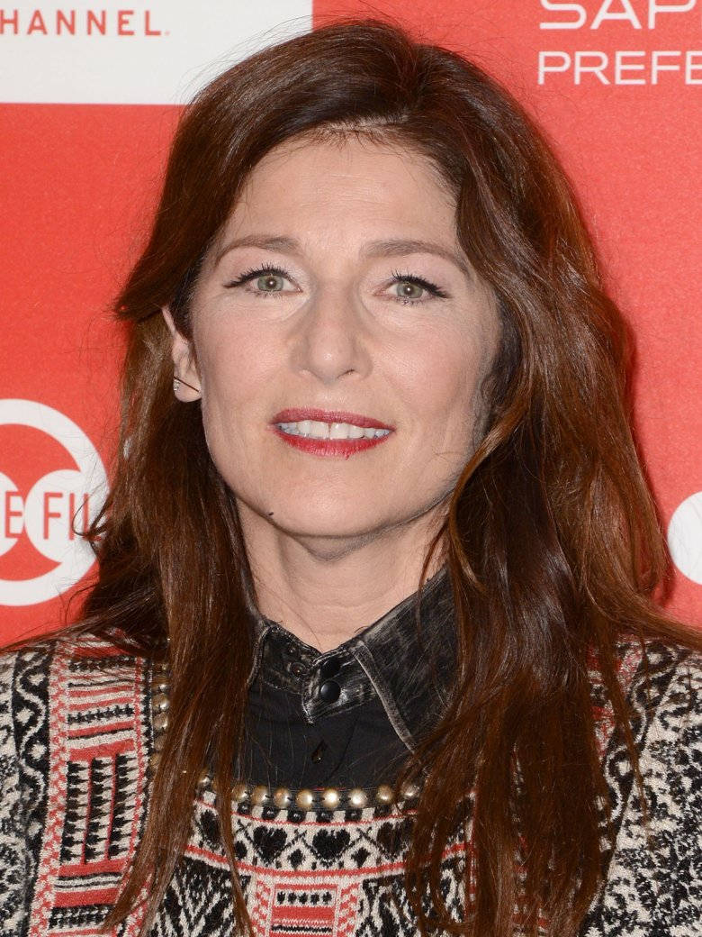 Celebrity 桌布 壁紙 — 一位擁有長長棕色頭髮和紅色唇膏的女性在紅色品牌背景前對著鏡頭微笑。