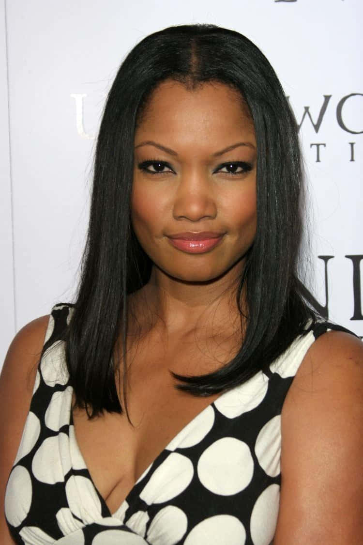 Garcelle Beauvais 桌布 壁紙 — 一位擁有長長黑髮和自信笑容的女性，在活動中穿著黑白圓點連衣裙。
