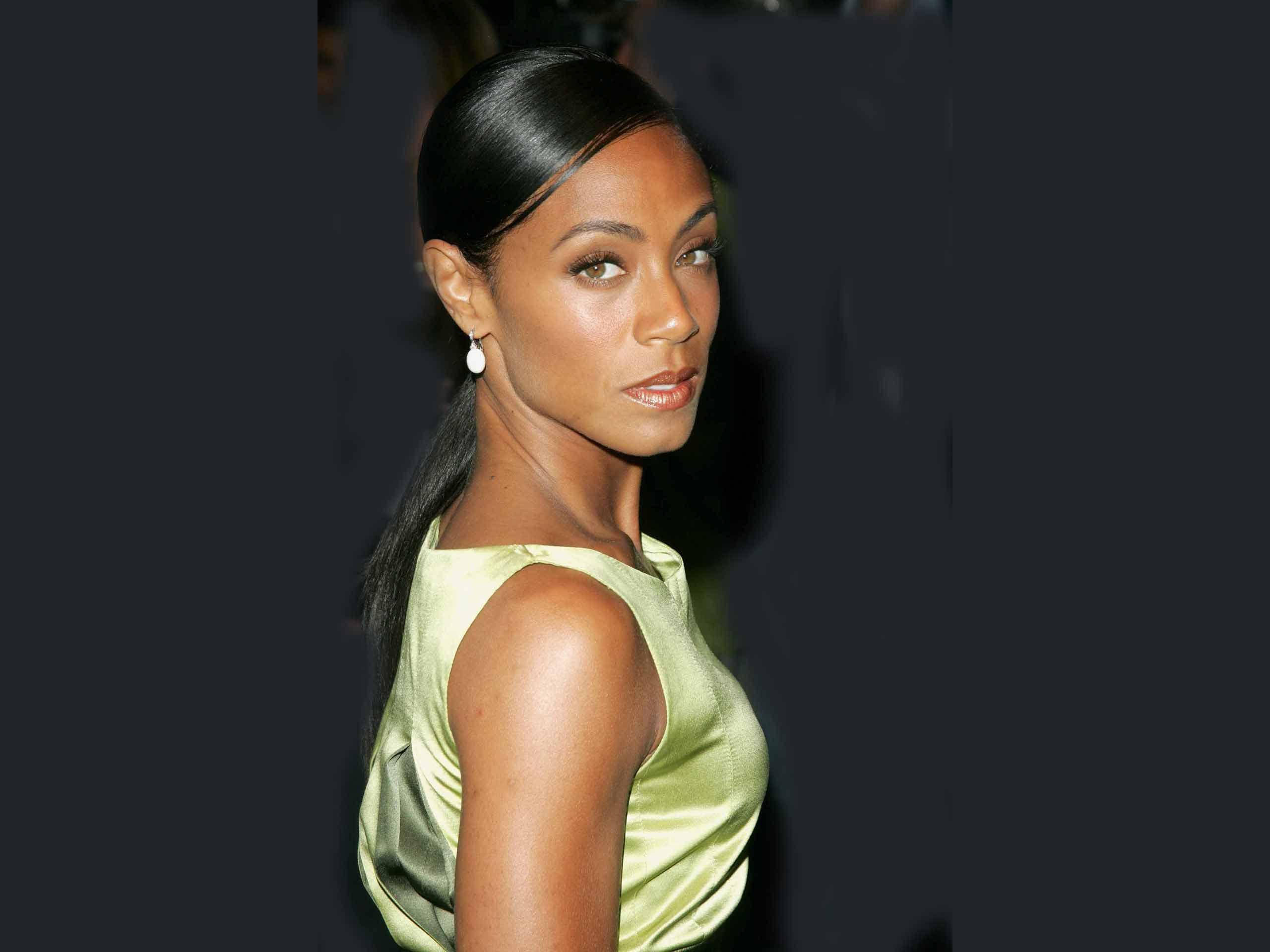 Celebrity 桌布 壁紙 — 一位擁有順滑黑髮、身穿綠色緞面連衣裙的女性在深色背景前自信地擺姿勢。