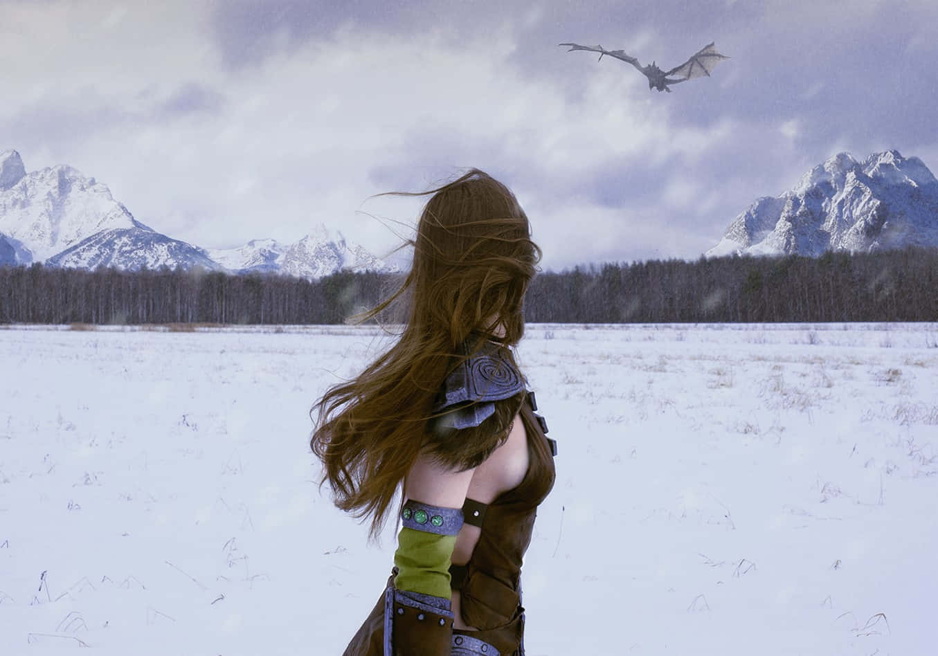 Aela The Huntress 桌布 壁紙 — 一位擁有飄逸棕色頭髮的戰士站在雪地裡，凝視著在陰天天空下飛越積雪山脈的龍。
