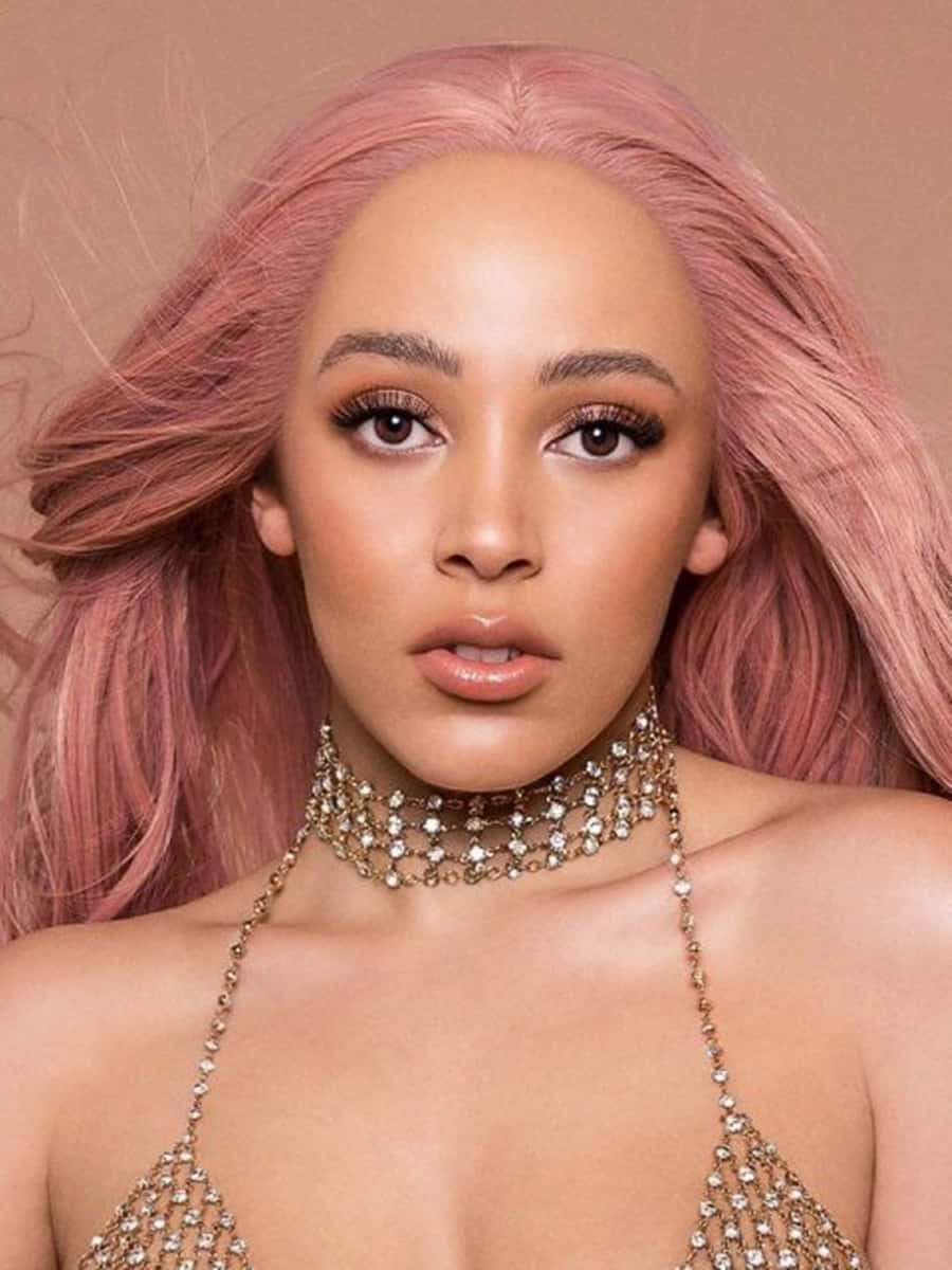 Doja Cat 桌布 壁紙 — 一位擁有飄逸粉紅頭髮和閃爍鑽石首飾的女性，在柔和米色背景下，以大膽妝容直視鏡頭。