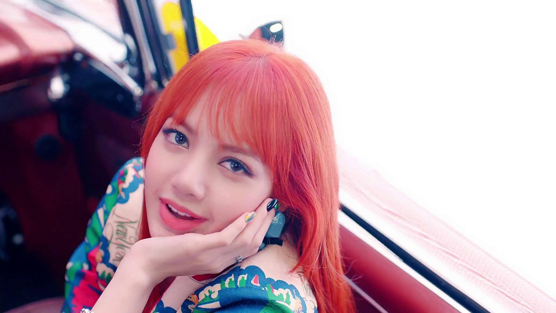 橙色頭髮女子在紅色車內微笑 — BLACKPINK Lisa GIF 壁紙