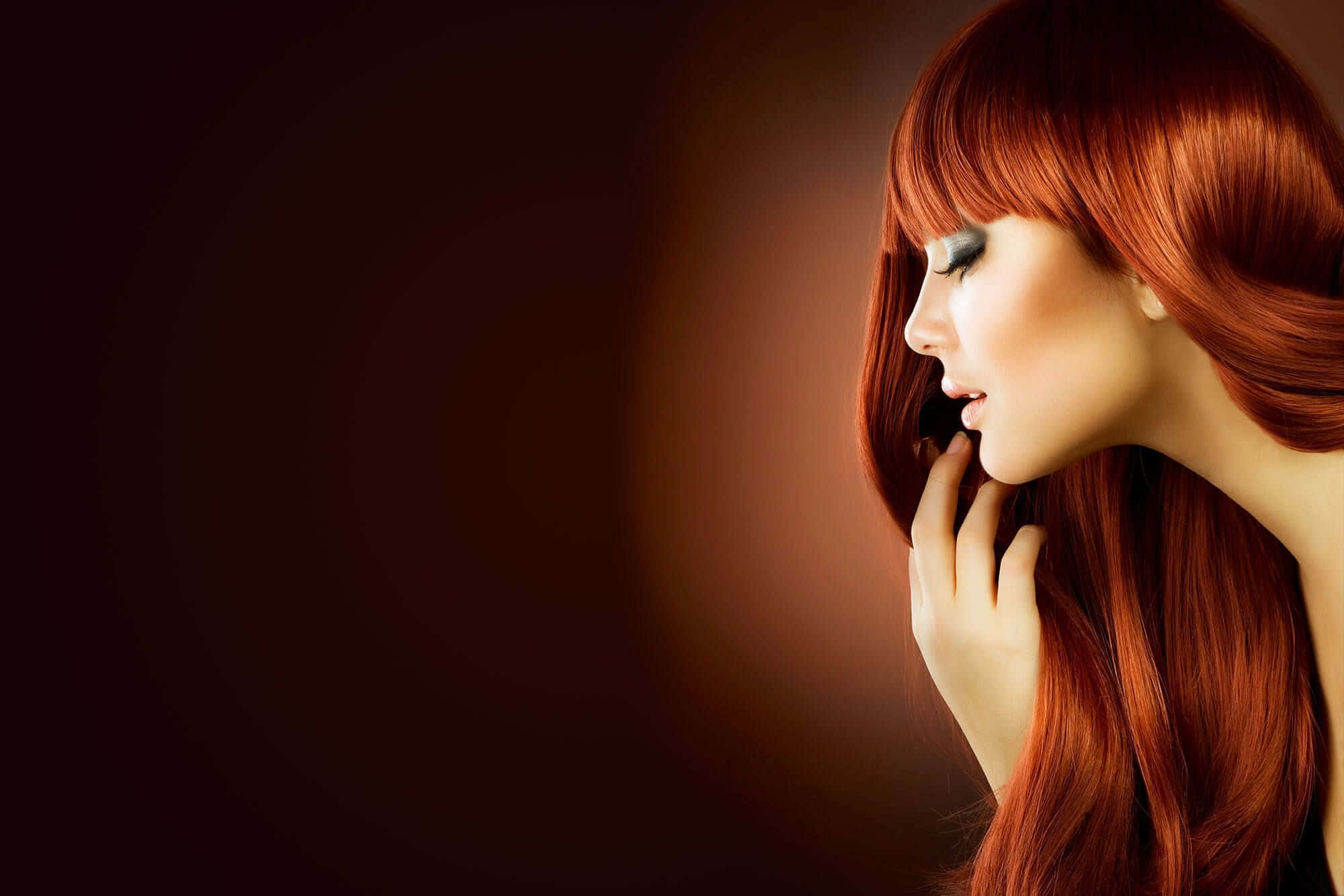 Haircare 桌布 壁紙 — 一位擁有鮮豔紅髮且閉著眼睛的女性，輕輕地將臉頰貼在深色漸變背景上。