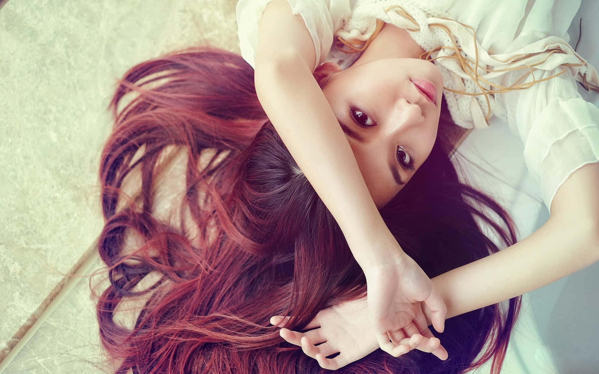 一位紅髮年輕女子躺在床上，抬頭看著相機。 — 漂亮的動圖 壁紙