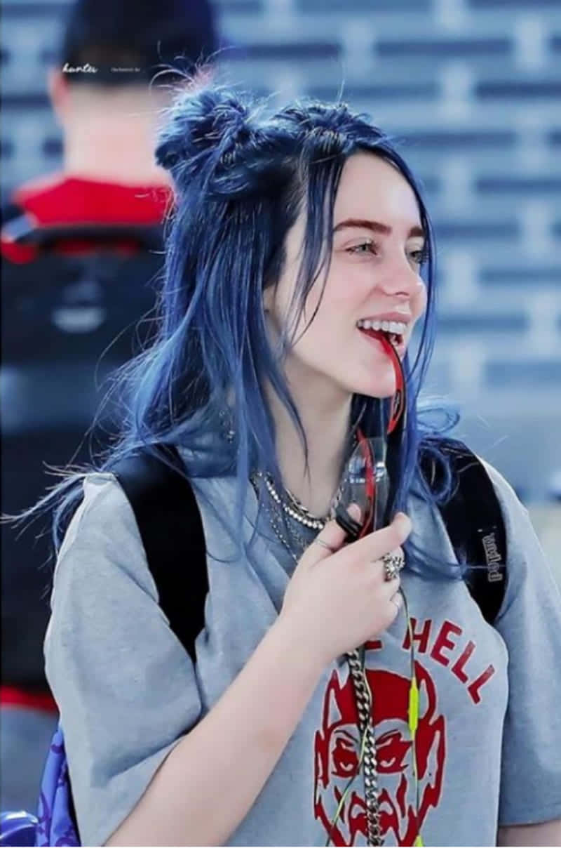 Dope Tumblr iPhone 桌布 壁紙 — 一位擁有鮮豔藍色頭髮的年輕女性在公共場所微笑，手持紅色棒棒糖。