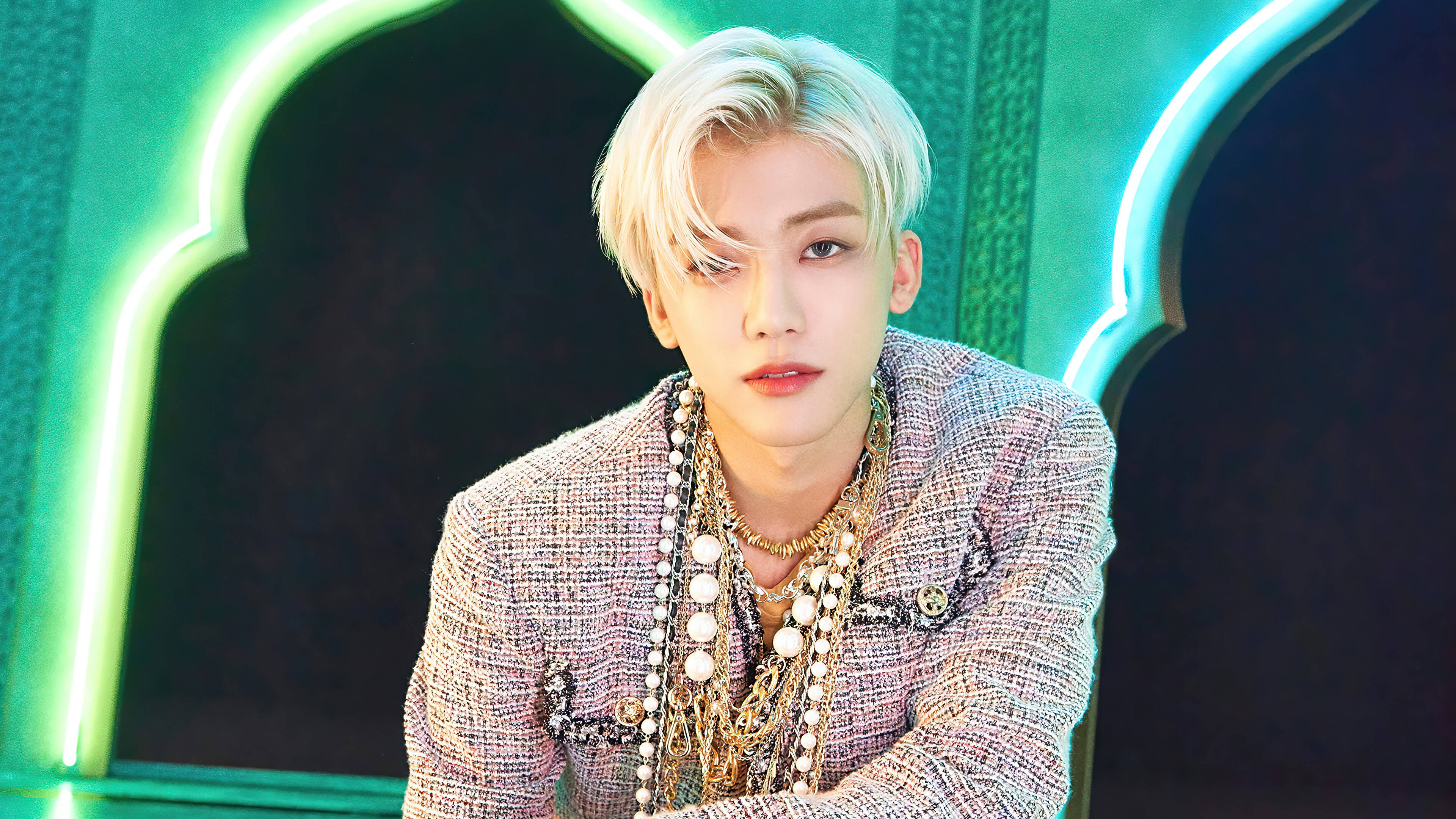 jaemin 桌布 壁紙 — 一位時尚人士，擁有鉑金色頭髮，穿著質感西裝外套和疊戴項鍊，背景是發光的綠色拱門。