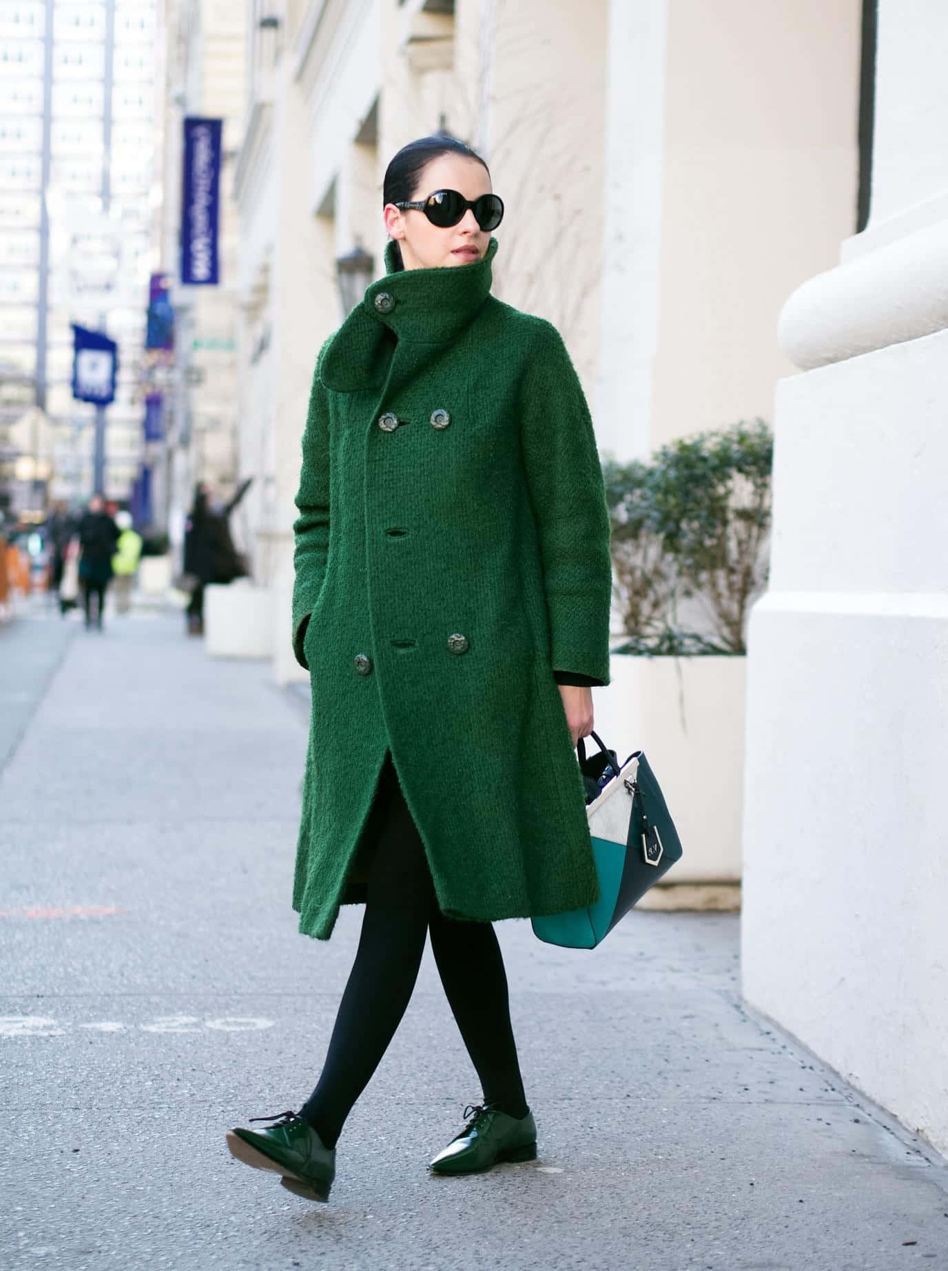 Green Fashion 桌布 壁紙 — 一位時尚女性穿著鮮綠色外套和相配的鞋子，自信地走在城市人行道上。