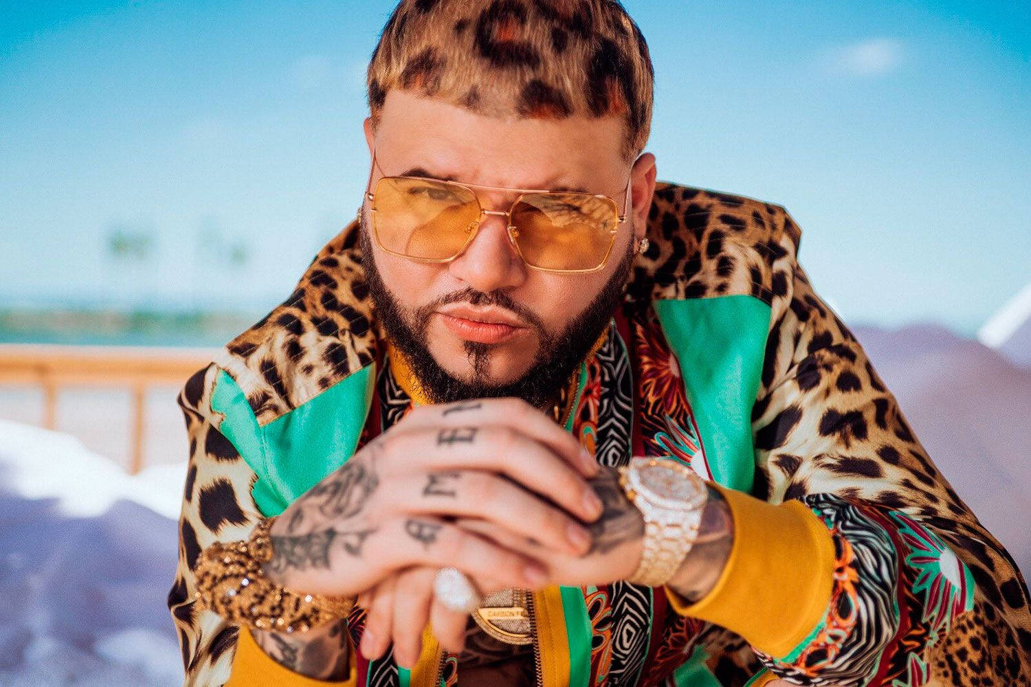 farruko 桌布 壁紙 — 一位時尚男士，擁有豹紋頭髮和外套，自信地戴著金色太陽眼鏡和刺青擺姿勢。