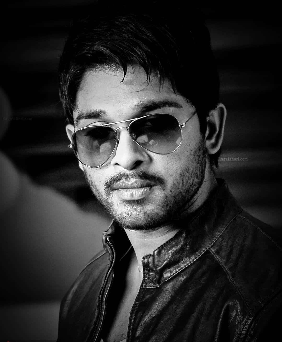 Allu Arjun 桌布 壁紙 — 一位時尚男士戴著飛行員太陽眼鏡和皮夾克，以自信的眼神在高對比度的黑白肖像中擺姿勢。