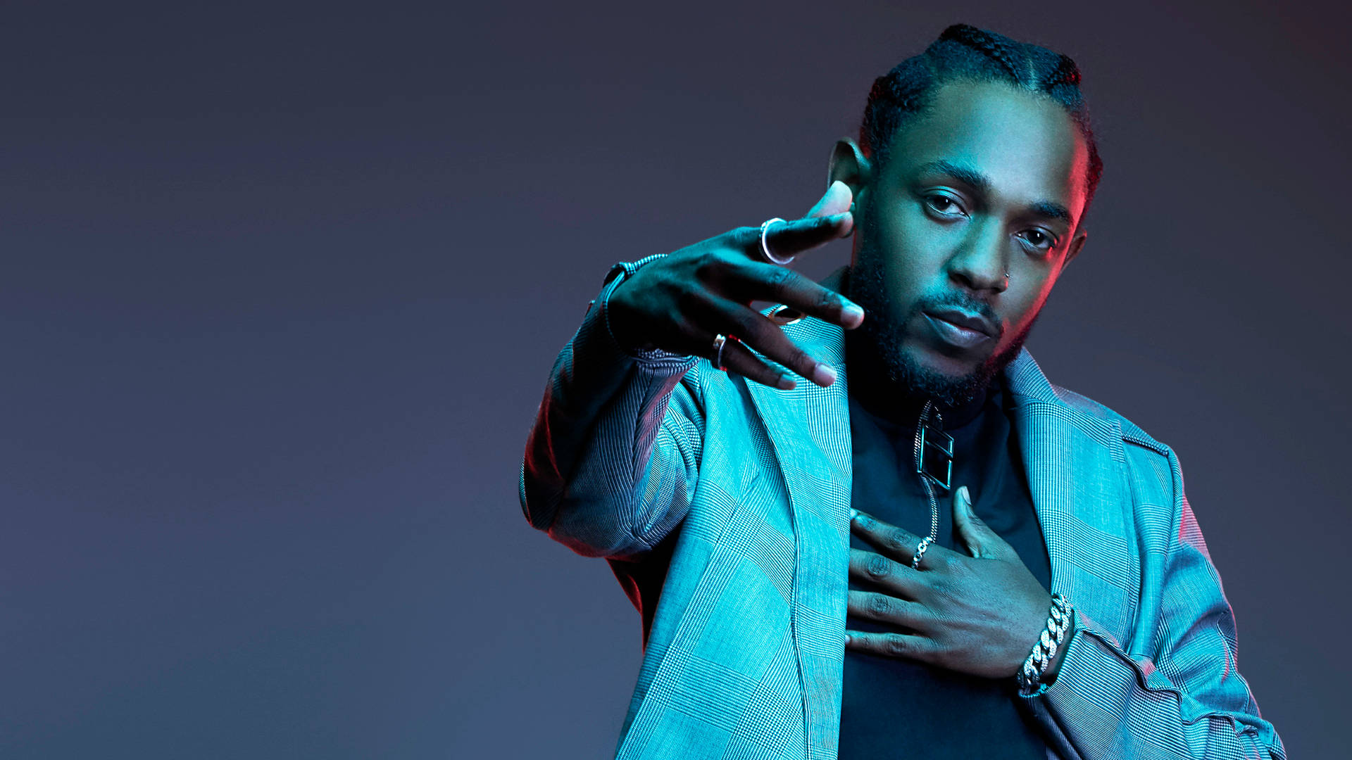 Kendrick 桌布 壁紙 — 一位時尚男士穿著格紋西裝外套，在戲劇性的藍色和紅色工作室燈光下自信地擺姿勢。