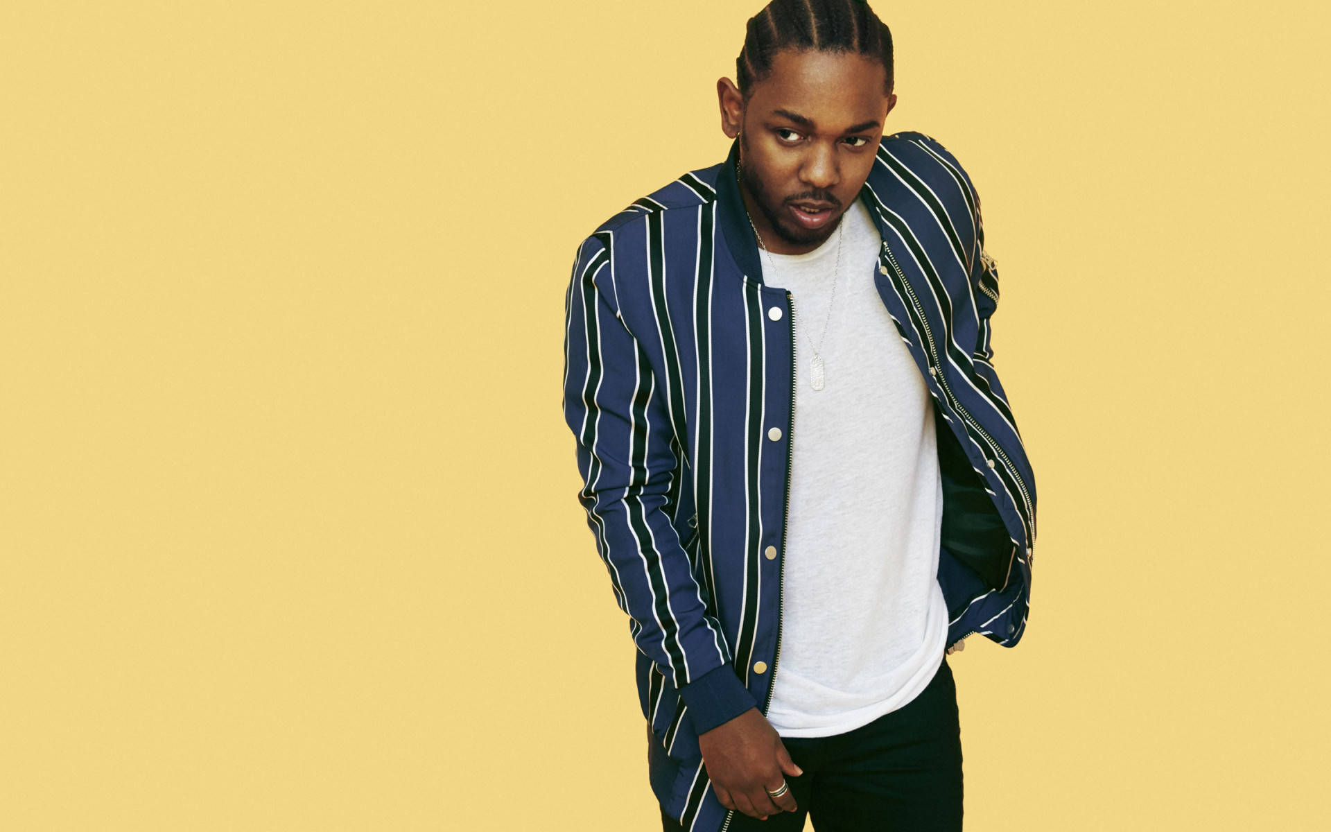 Kendrick 桌布 壁紙 — 一位時尚男士身穿藍色條紋外套和白色T恤，在純黃色背景前自信地擺姿勢。