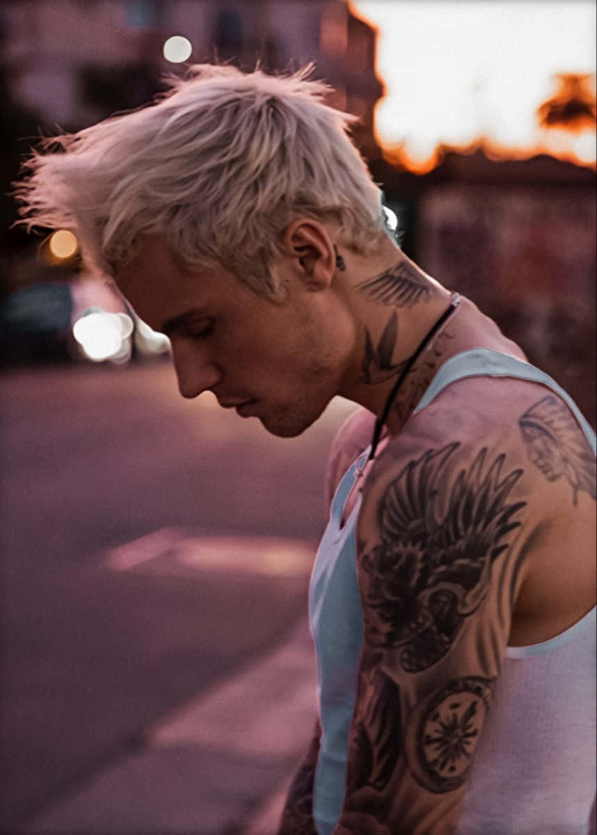 Justin Bieber 2021 桌布 壁紙 — 一位有刺青、鉑金色頭髮的男子在日落時分俯瞰城市街道，背景是溫暖的散景燈光。