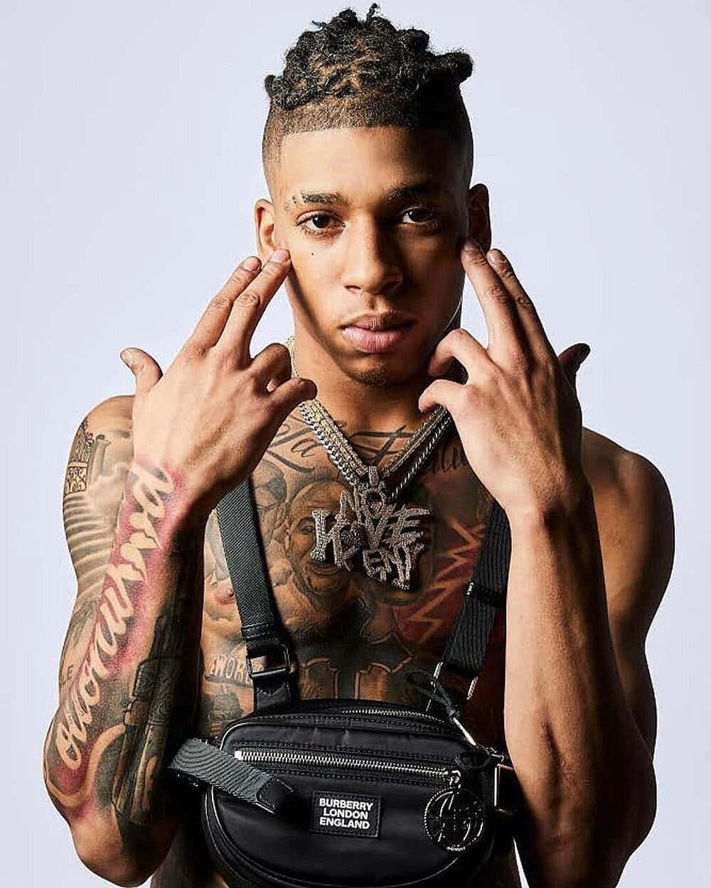 佩戴黑色Burberry腰包和鏈條的刺青男士的攝影棚肖像。 — NLE Choppa GIF 壁紙
