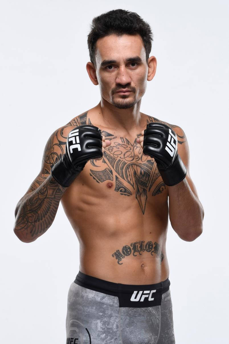 UFC 桌布 壁紙 — 一位有刺青的UFC拳手，戴著黑色手套和灰色短褲，在純白色背景前自信地擺姿勢。