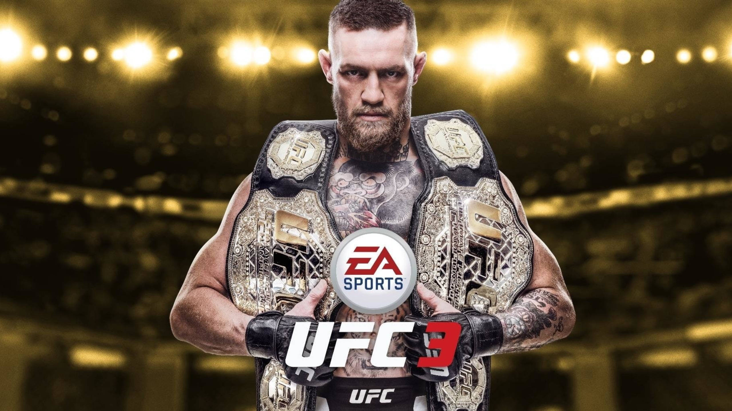 Mcgregor 桌布 壁紙 — 一位有刺青的UFC拳手，腰間掛著冠軍腰帶，站在體育館燈光下明亮的競技場中。