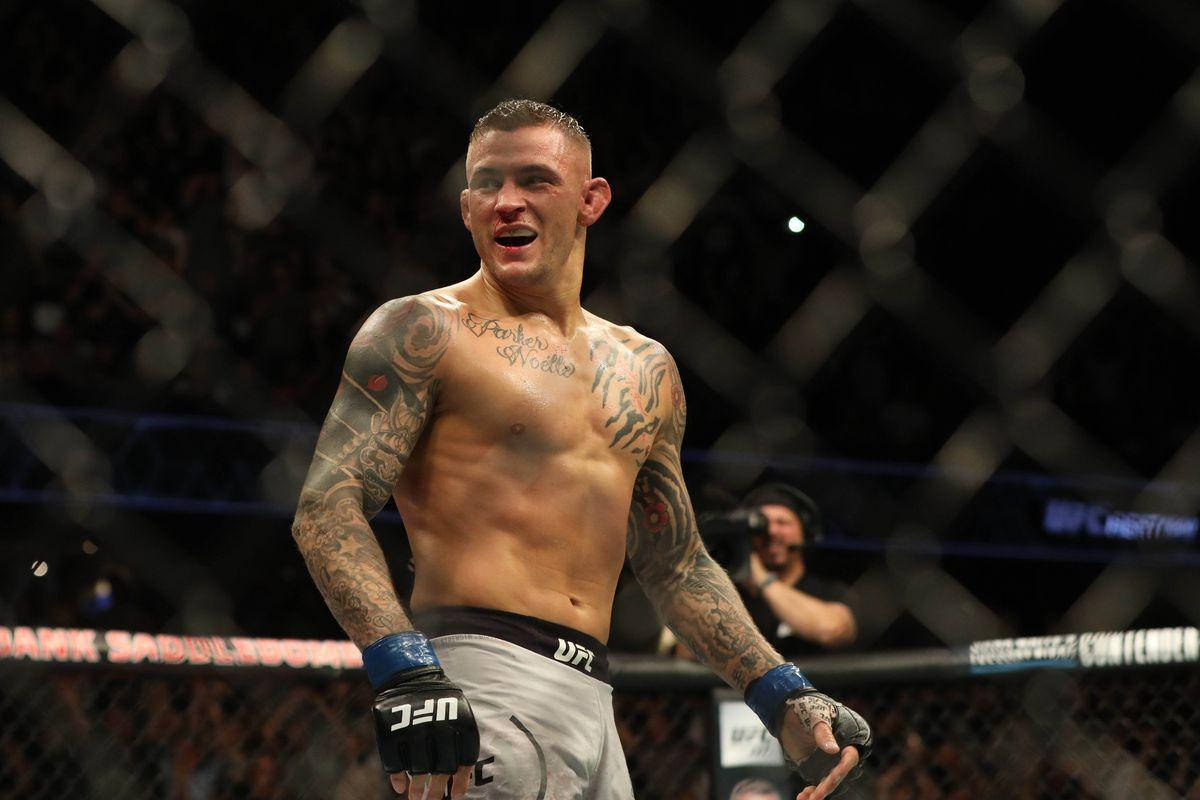UFC 桌布 壁紙 — 一位有刺青的混合武術家在UFC八角籠內慶祝勝利，背景是人群。
