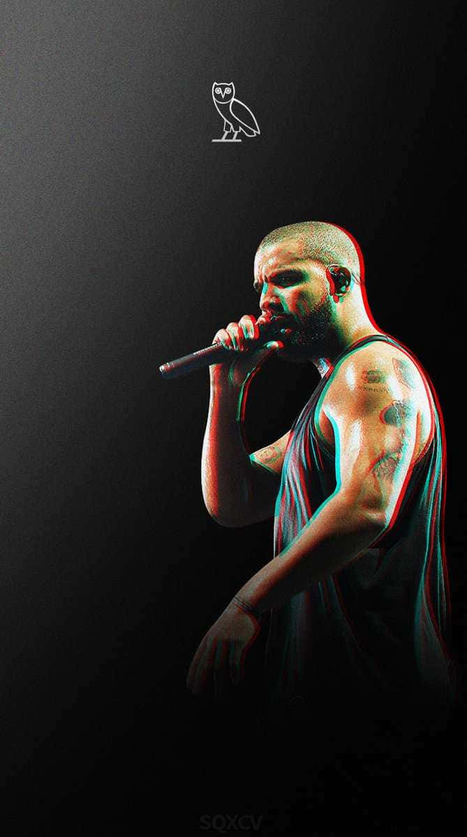 Drake 桌布 壁紙 — 一位有刺青的饒舌歌手在黑色背景帶有貓頭鷹標誌的環境中，於戲劇性的紅色和青色燈光下對著麥克風唱歌。