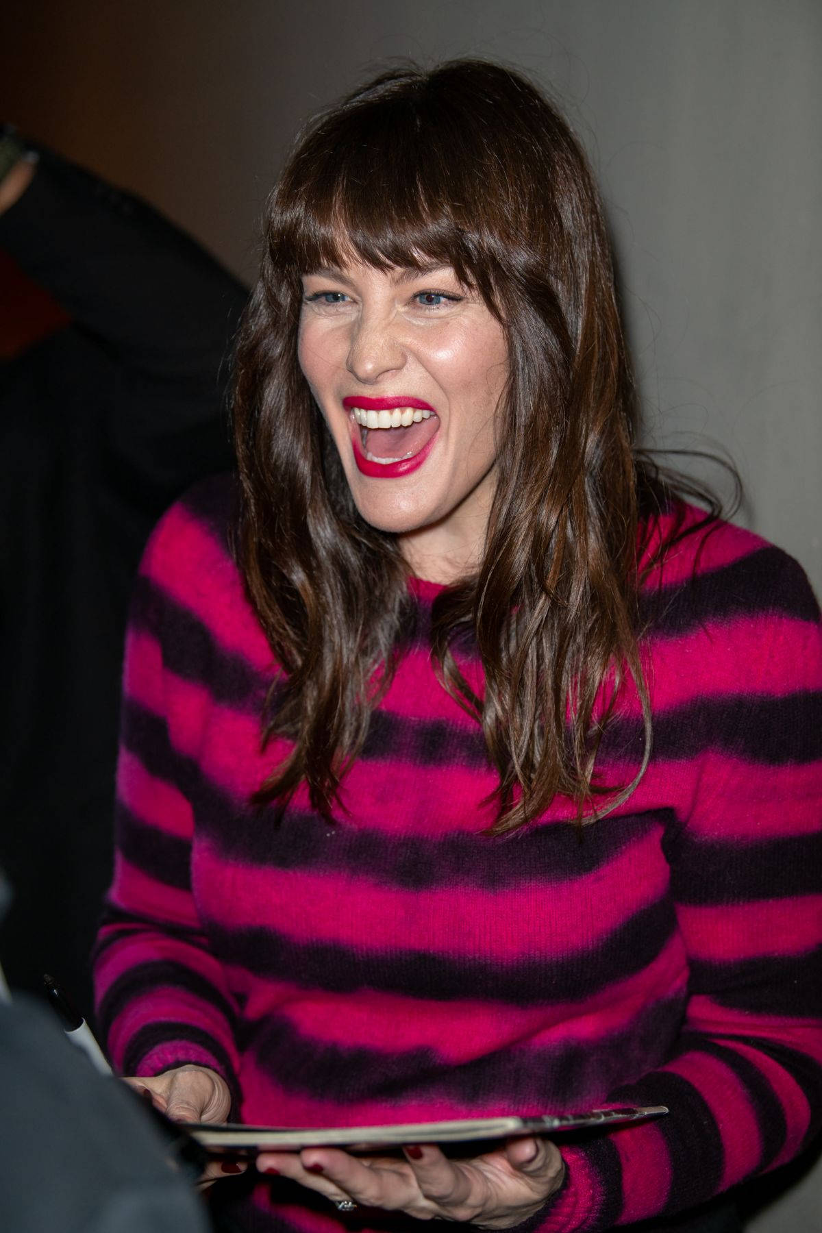 Liv Tyler 桌布 壁紙 — 一位棕色頭髮、塗著鮮紅色唇膏的女性，穿著粉黑條紋毛衣，開懷大笑。