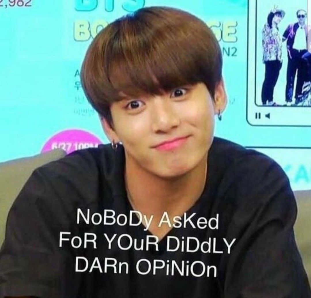 Bts Funny 桌布 壁紙 — 一位棕色頭髮、粉紅色嘴唇的年輕男子穿著黑色襯衫，上面有粗體白色文字覆蓋，露出得意的笑容。